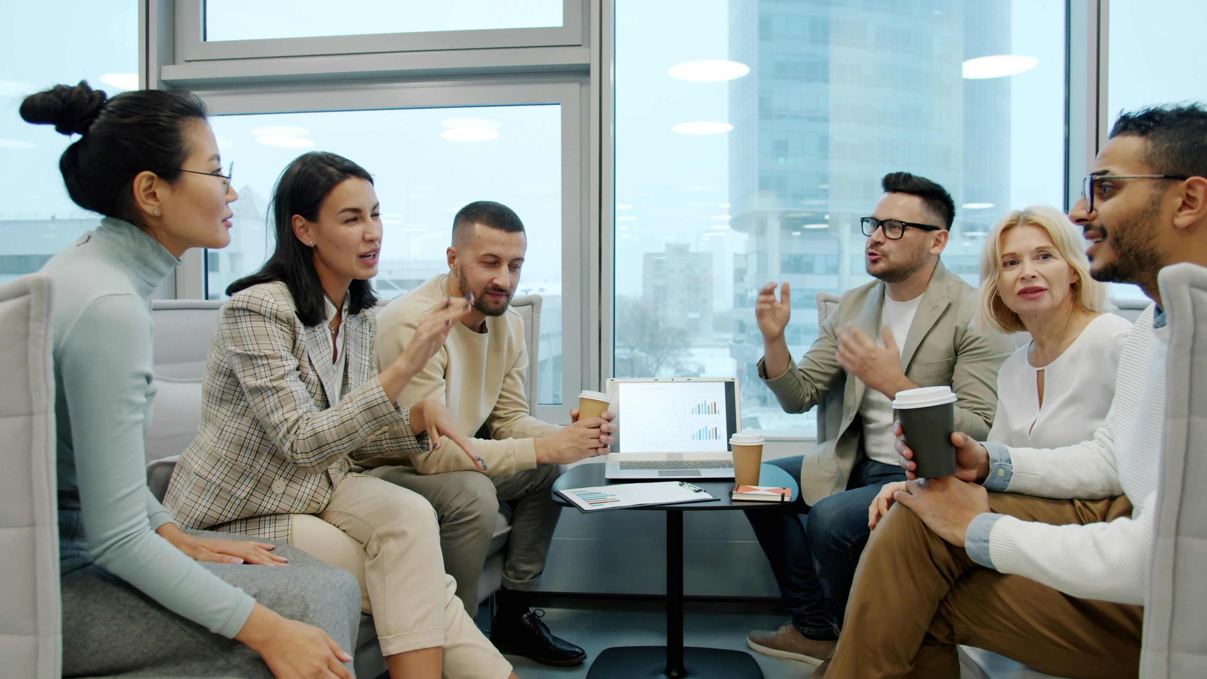 A diverse group talking in a relaxed office lounge